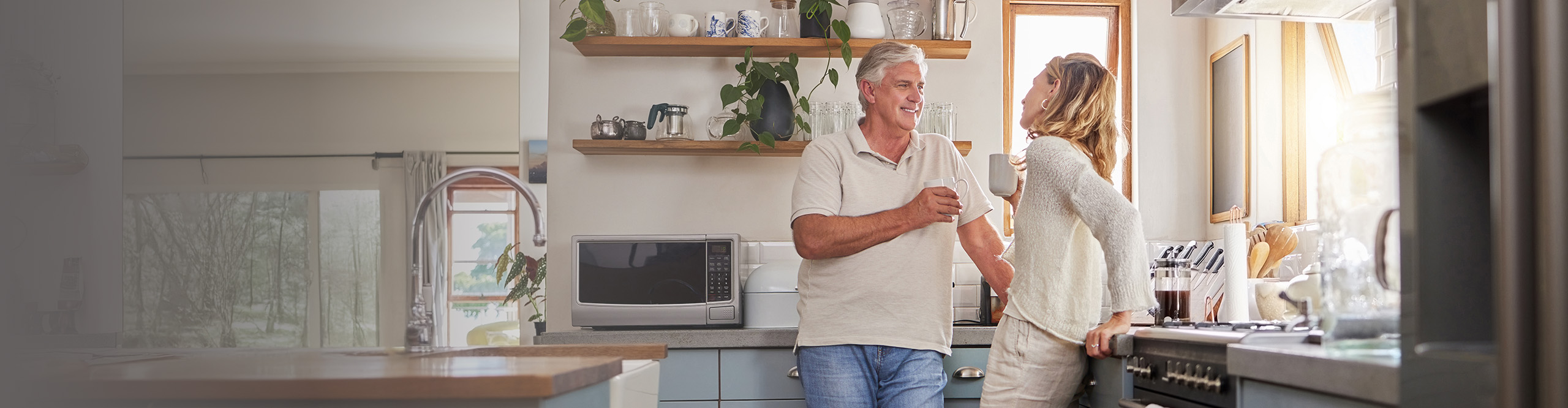 older man and woman couple talking in the kitchen