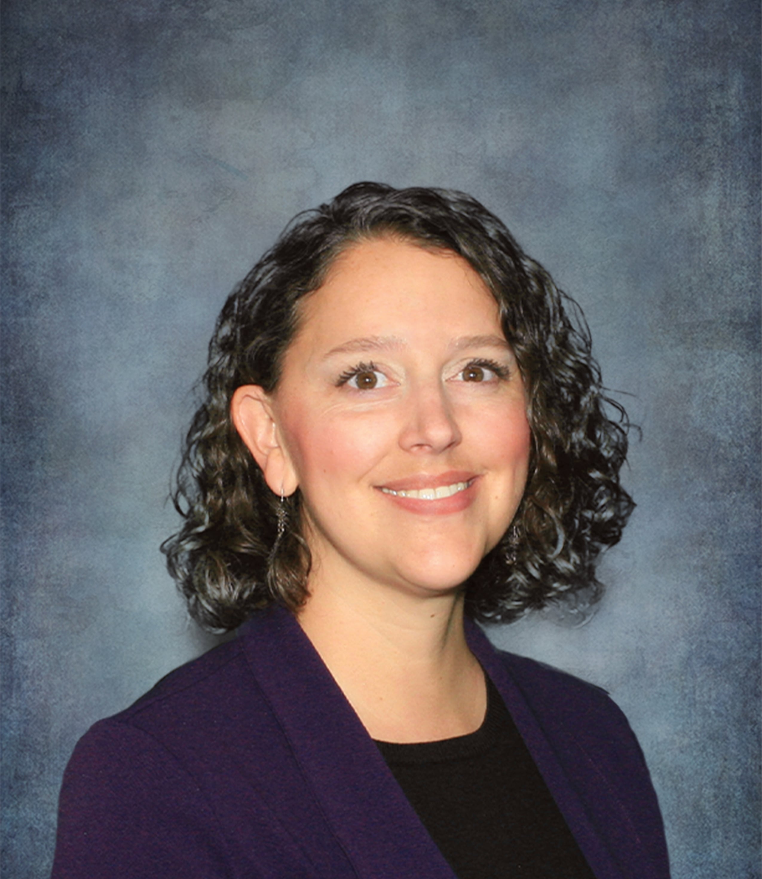 headshot of rachel wearing a purple cardigan and a black shirt 