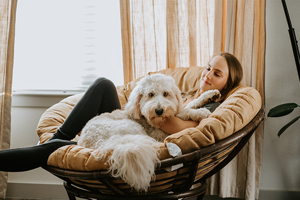 woman sitting on her couch with dog in her lap