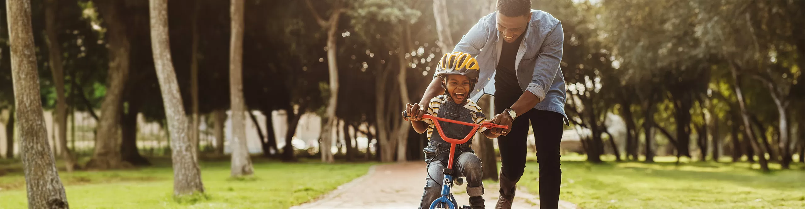 dad teaching son to ride a bike