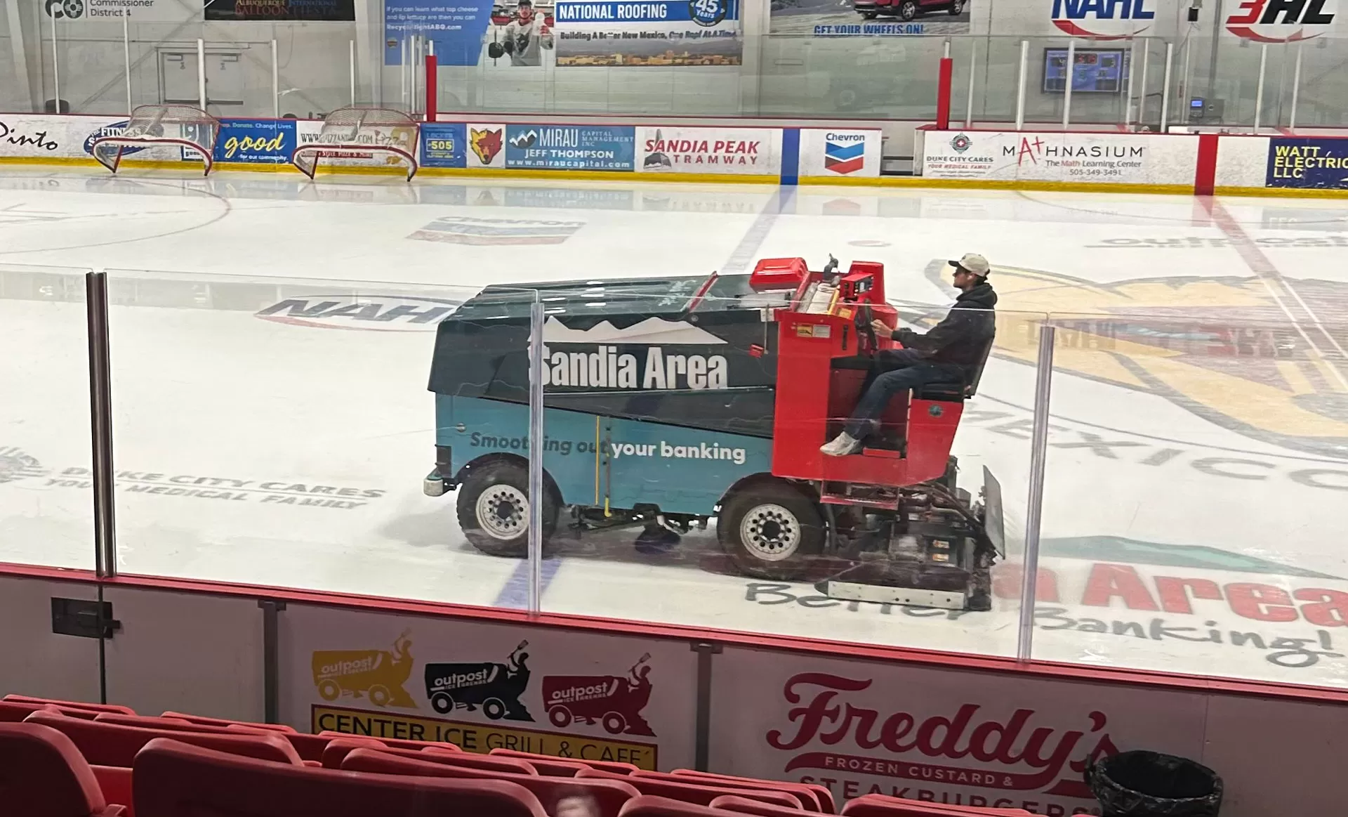Zamboni wrapped with Sandia Area FCU branding on the ice