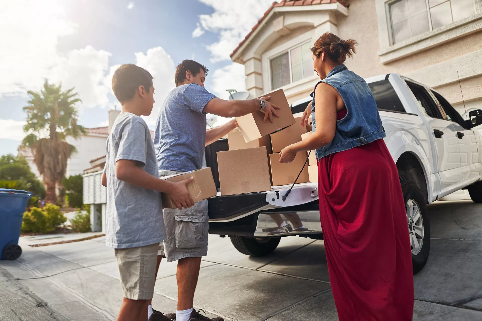 Hispanic family unloading pickup truck to move into home