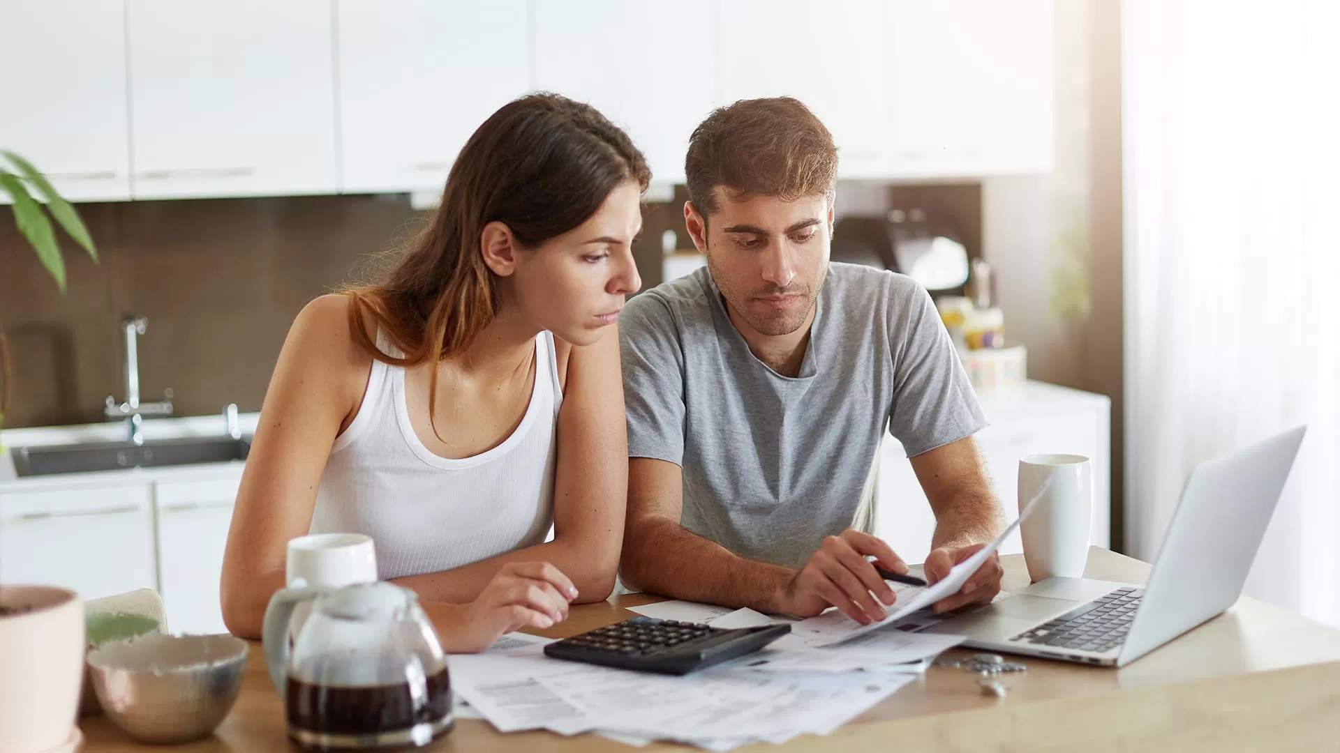 Woman looking at papers in front of laptop