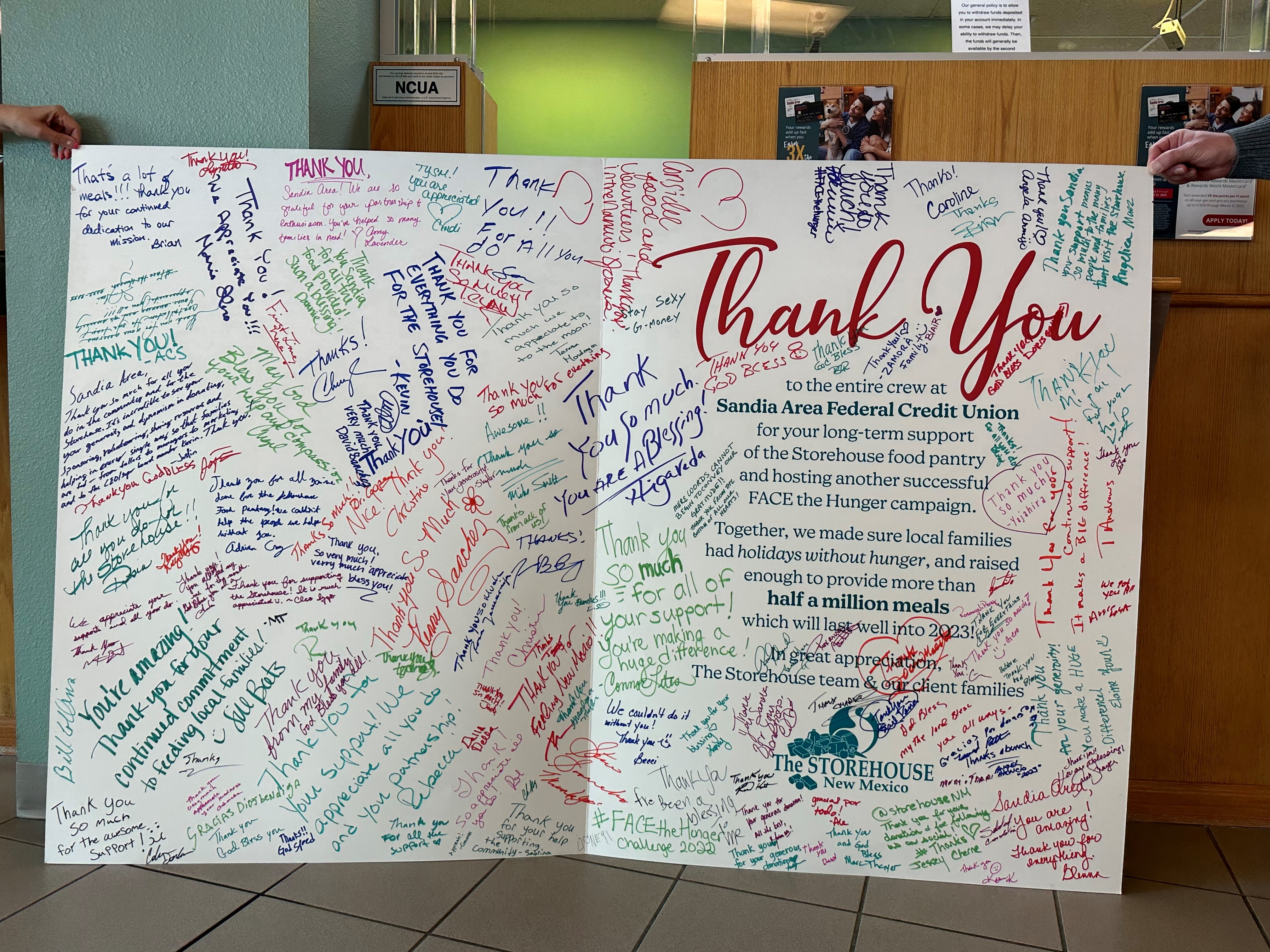 giant thank you card filled with signatures stands open